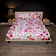 Bed with floral bedding in a bedroom setting with nightstands and lamps.