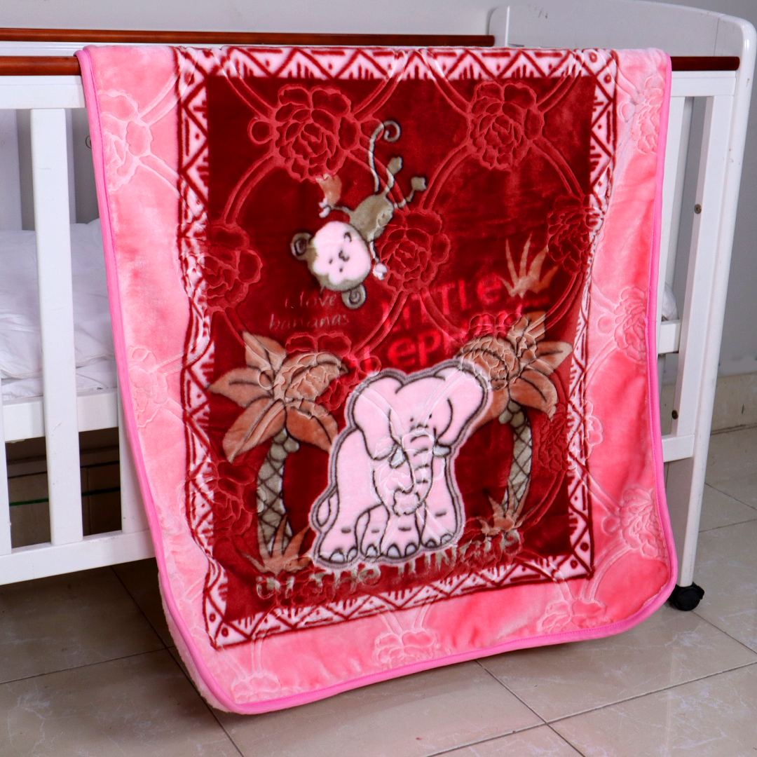 Decorative baby blanket with elephant design on a crib