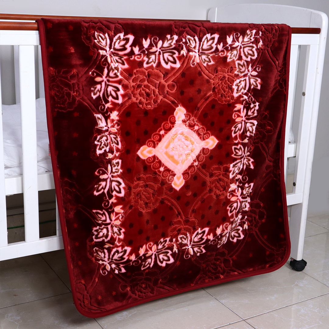 Red embroidered blanket draped over a white crib with floral patterns