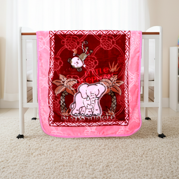Pink and red baby blanket with elephant design on a crib