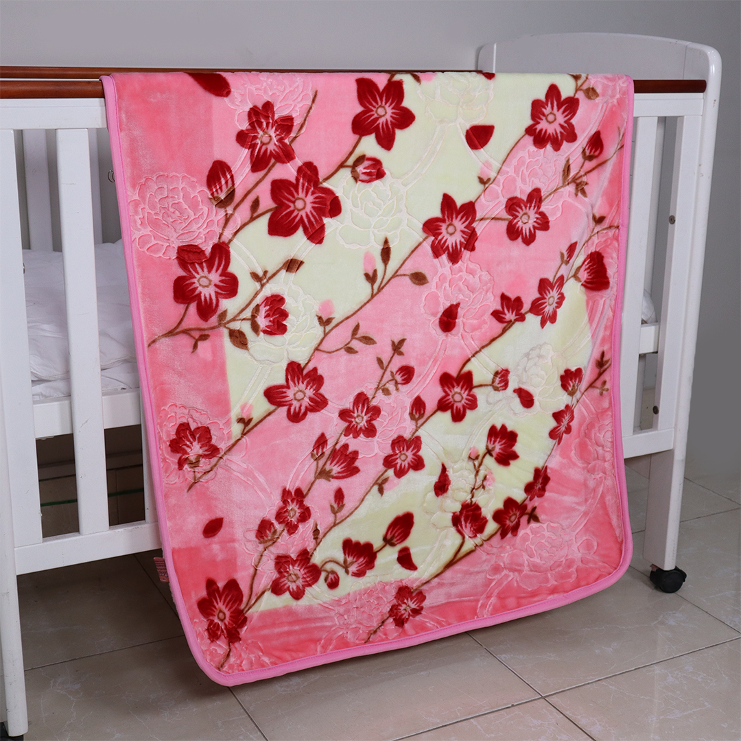 Pink floral blanket draped over a crib