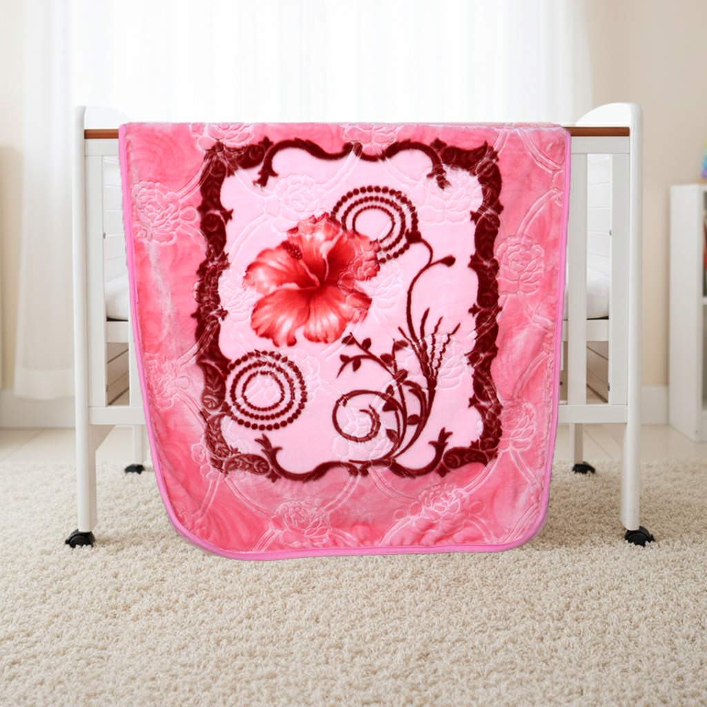Pink floral blanket draped over a white crib with a red flower design.