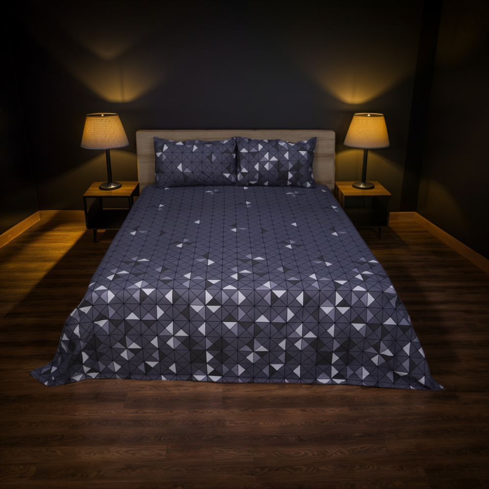 Bed with geometric patterned comforter in a dimly lit room with two lamps.