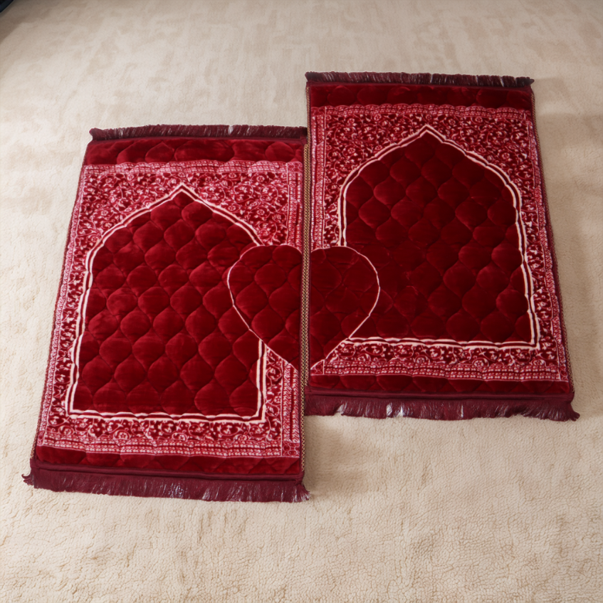 Two red prayer mats with intricate designs on a beige surface