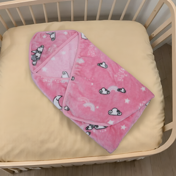 Pink blanket with cloud patterns on a beige crib