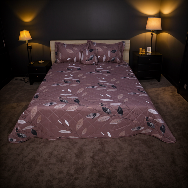 Bed with a patterned comforter in a dimly lit bedroom