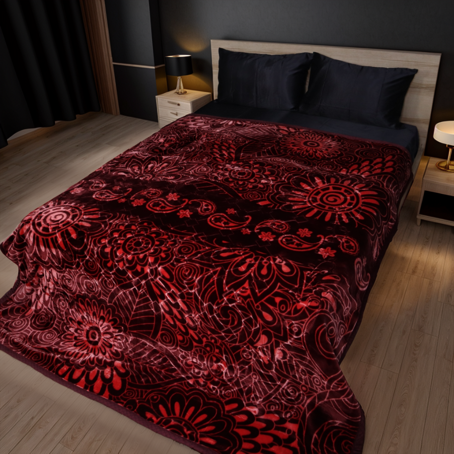 Bed with a red and black patterned comforter in a bedroom setting.