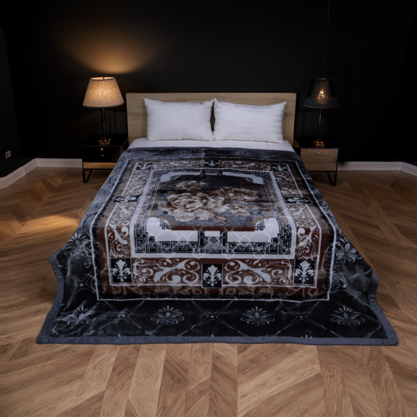Decorative blanket with intricate patterns on a bed in a bedroom setting.