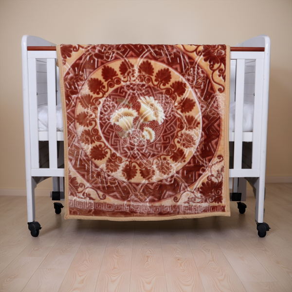 Decorative blanket with floral pattern draped over a crib on a wooden floor.